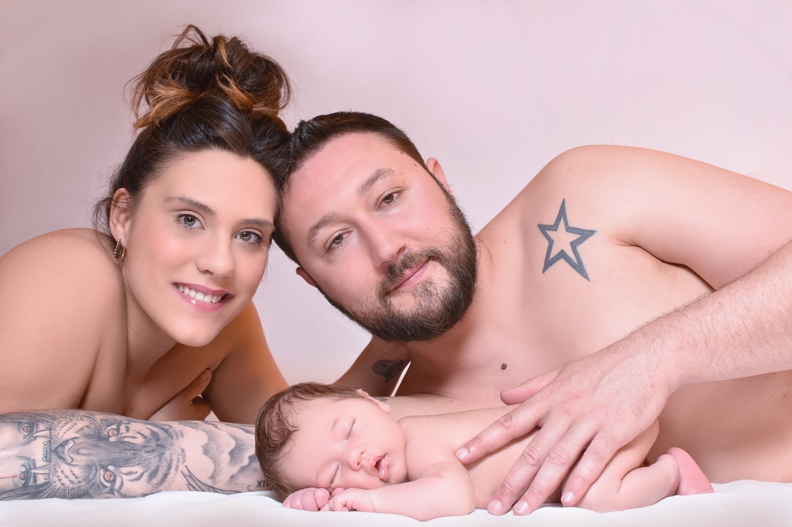 Padres abrazando a su bebé recién nacido al final de la sesión newborn