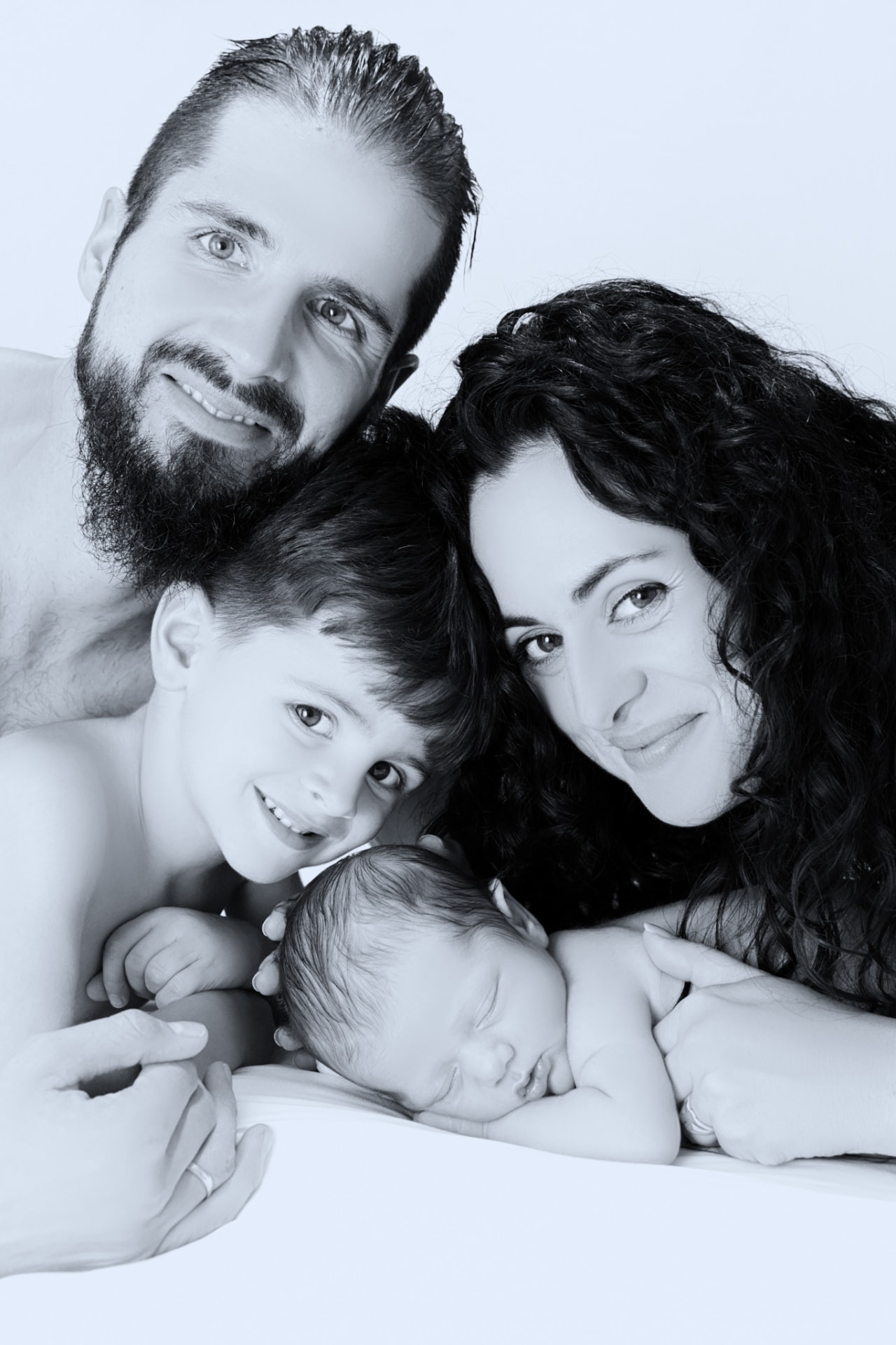 Retrato familiar en blanco y negro de padre, madre, hermano mayor y bebé recién nacido juntos