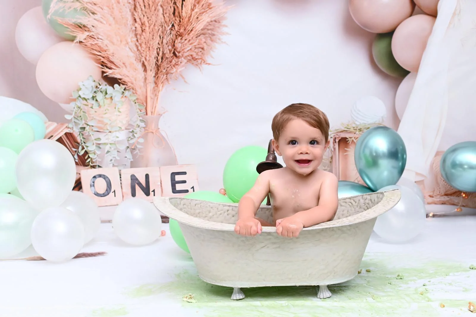 Bebé sonriente dentro de una bañerita después de una sesión Smash Cake Deluxe