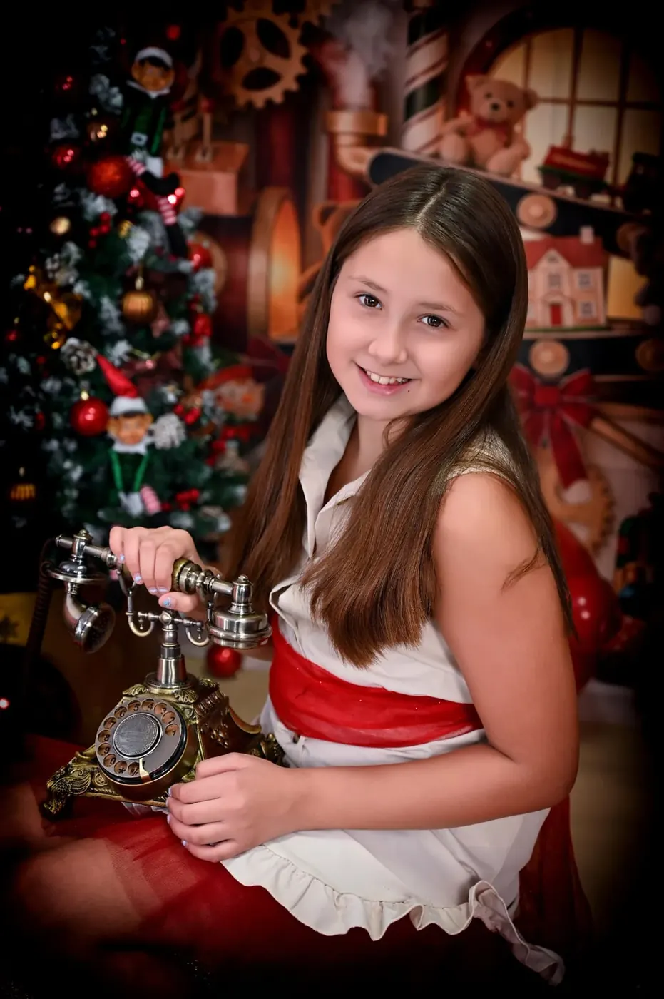Niña escuchando una llamada en el taller navideño